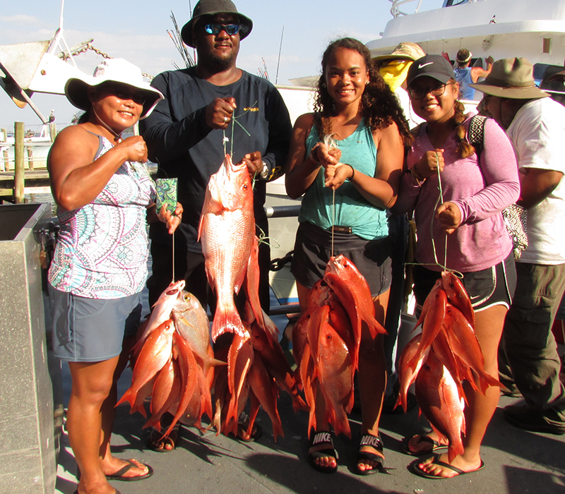 Book a deep sea fishing trip in Panama City Beach Florida. Family holding fresh catch from charter fishing trip.